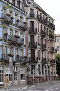 an old building with balconies and flowers on the windows is next to a crosswalk