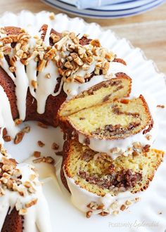 a bundt cake with white frosting and nuts on top is cut in half