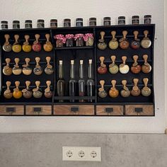 an assortment of liquor bottles on display in a wall mounted wine rack with wooden knobs