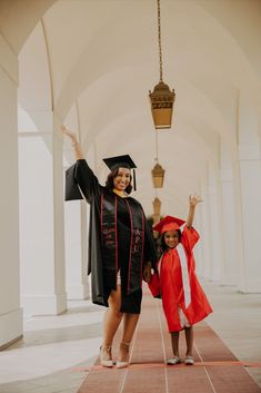 two girls in graduation gowns and caps are posing for the camera with their arms up