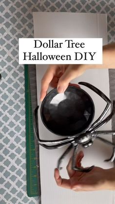 a person is holding a black ball in front of a spider web with the words dollar tree halloween diy on it