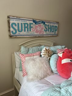 there is a surf shop sign above the bed