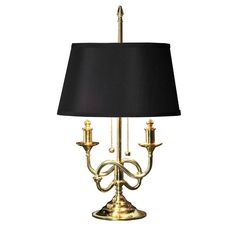 a lamp with a black shade on it and a gold finish is the focal point for this table lamp