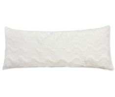 a white pillow with wavy design on the front and back, sitting on a white surface