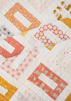 an orange and yellow patchwork quilt with different designs on it's edges,