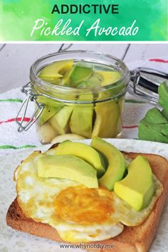 an egg and avocado sandwich on toast with pickles in the jar next to it