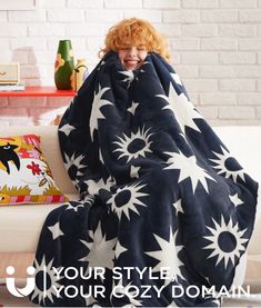 a woman wrapped in a black and white flowered blanket with the words your style, your cozy domain