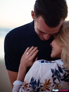 a man and woman embracing each other on the beach