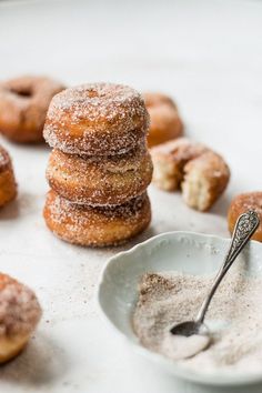 powdered doughnuts stacked on top of each other with a spoon next to them