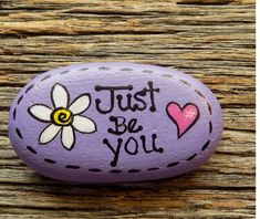 a painted rock that says, just be you with a flower and heart on it