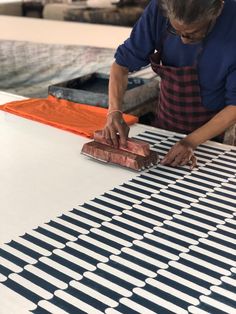 a man is working on an art project with wood and metal strips in front of him