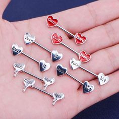 six heart shaped lapel pins with the word love on them in different colors and sizes