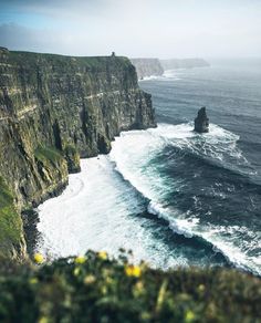 an ocean cliff with waves crashing against it