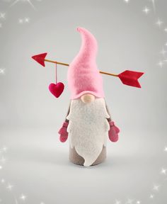 a stuffed gnome holding an arrow and heart