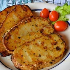 three pieces of bread on a plate with tomatoes and lettuce next to it