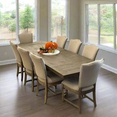 a dining room table with chairs and plates on it in front of large windows that look out onto the yard