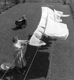 an old photo of a woman holding onto a sail