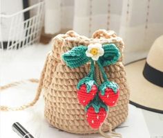 a straw bag with two cherries on the front and one strawberry on the back