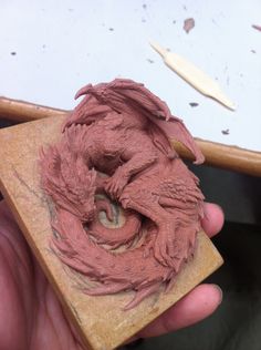 a person is holding a clay sculpture in their hand and it looks like they are making something out of clay