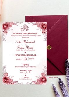 the wedding card is displayed next to some purple and red glittery flowers on it