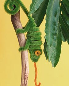 a green caterpillar hanging from a tree branch