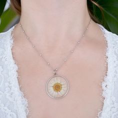 The white daisy necklace comes with a stylish 925 silver-plated chain. The beaded chain is made in Italy and it is crafted beautifully.  The pressed and dried flower pendant is real and covered in resin. Its shape and color may vary since flowers come in different sizes.  The chain is approximately long 21 cm. This is the perfect gift for a Birthday and Valentine's Day, but also for a bride and her bridesmaids.  The necklace has a small mark on it that certifies it's made of 925 silver.  Each pi Silver Dainty Birth Flower Necklace, Minimalist Silver Jewelry With Pressed Flowers, Silver Hypoallergenic Flower Necklace, Dainty White Round Flower Necklace, Silver Birth Flower Round Pendant Necklace, Elegant White Pressed Flower Necklace, Dainty Daisy Silver Jewelry, Silver Flower Necklace With Pressed Flowers, Sterling Silver Flower Jewelry With Pressed Flowers