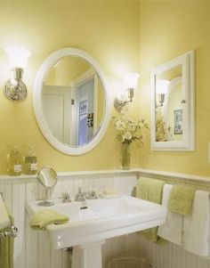 a bathroom with yellow walls and white fixtures