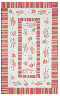 a pink and green striped quilt with flowers on it's border, in front of a white background