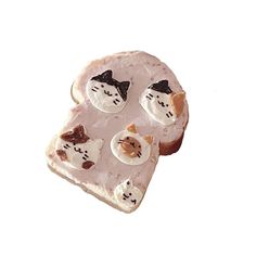 there is a piece of bread with frosting and toppings in the shape of cats