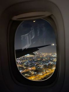 an airplane window looking out at the city lights