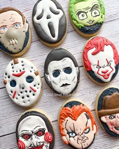 halloween cookies decorated to look like they have faces painted on them, and one is wearing a mask