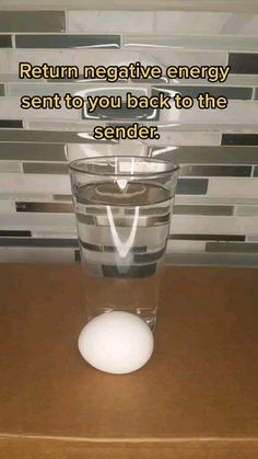 a glass filled with water sitting on top of a wooden table