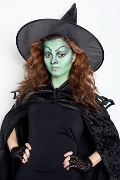 a woman dressed as a witch poses for the camera