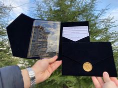 a person holding up an envelope with a gold coin in it and a card inside