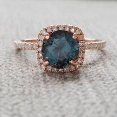 a close up of a ring with a blue stone in the center and diamonds around it