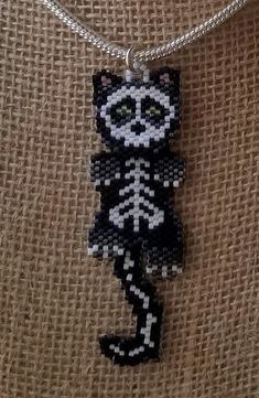 a black and white cat beaded on a silver chain