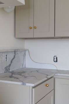 a kitchen with marble counter tops and cabinets