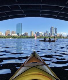 a kayak is seen from the water in front of a city skyline