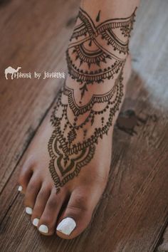 a woman's foot with hennap and white nail polishes on it