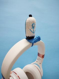 headphones on top of a white object with an anchor and blue ribbon around it