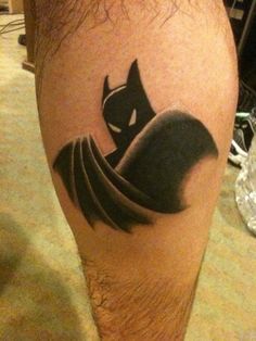 a man with a batman tattoo on his leg