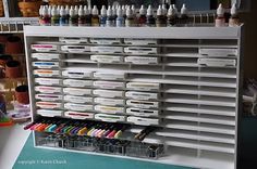 an art supply stand with lots of paint and markers on it's sides,