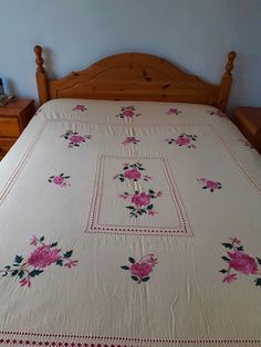 a bed with pink flowers on it in a bedroom