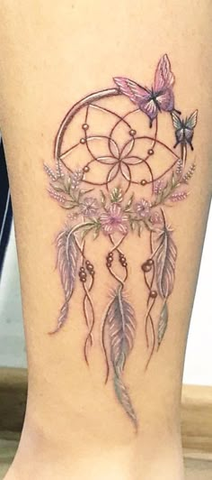 a woman's leg with a tattoo on it that has an image of a dream catcher