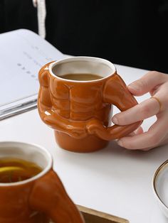 a person is holding a coffee mug in their hand