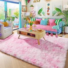 a living room filled with lots of furniture and pink rugs on top of a hard wood floor