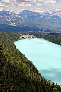 a blue lake surrounded by pine trees and mountains