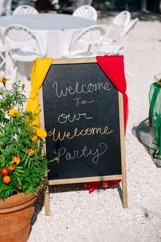 a welcome sign sitting in front of a table with chairs and tables set up for an event