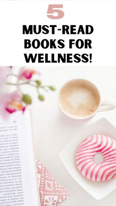 a cup of coffee next to a donut on top of a white table with pink flowers