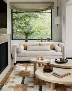 a living room filled with furniture and a fire place in front of a large window